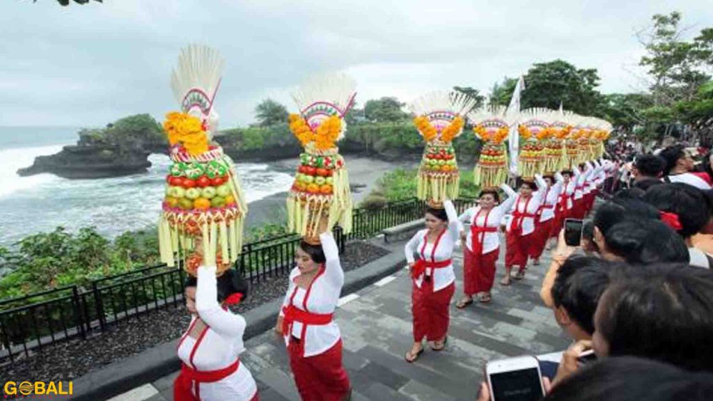 Pertunjukan tari tradisional dengan latar matahari terbenam di Pura Tanah Lot