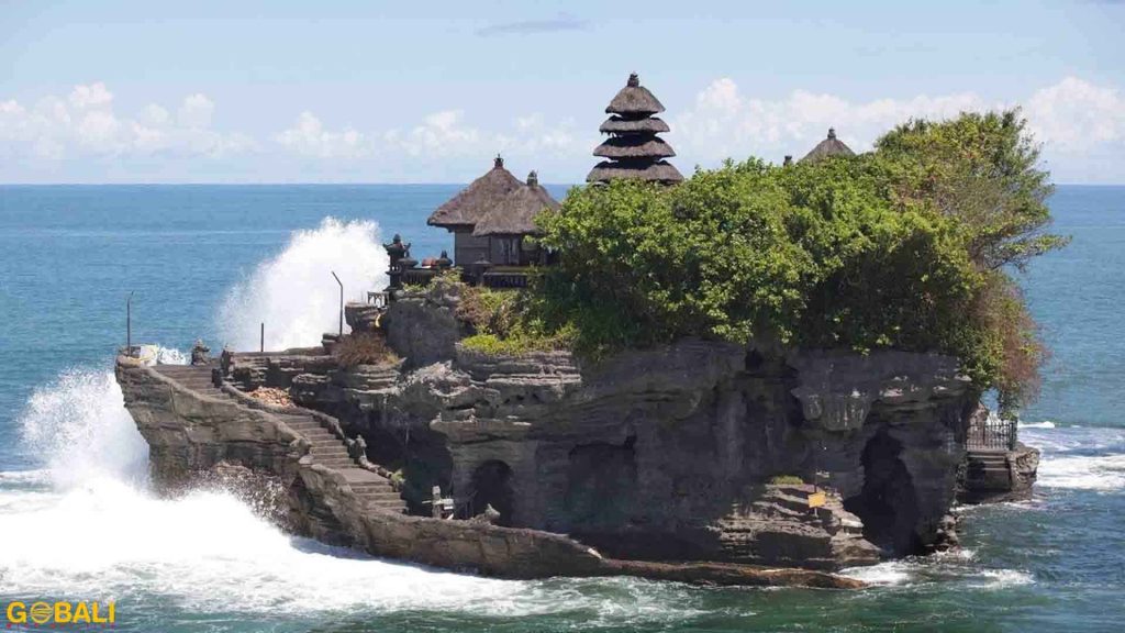 Pura Tanah Lot di atas batu karang dengan pemandangan laut.